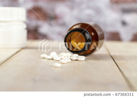 Home medicine.Glass bottles of medicine and roubd white pills Home medicine.Glass bottles of medicine and roubd white pills 67368331