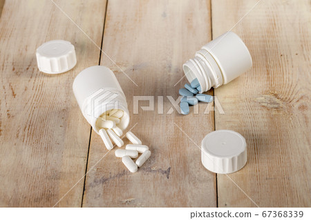 Home medicine.White plastic pill bottles and different pills Home medicine.White plastic pill bottles and different pills 67368339