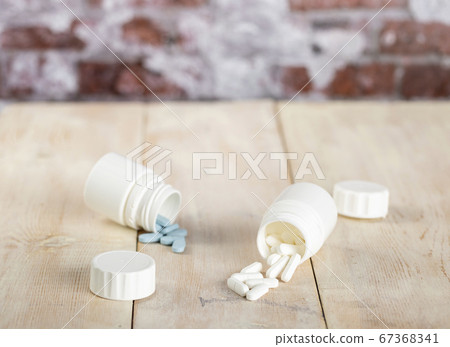 Home medicine.White plastic pill bottles and different pills Home medicine.White plastic pill bottles and different pills 67368341
