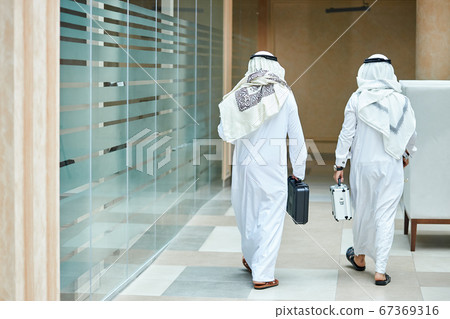 Back view on arabian sheikhs going to business meeting Back view on arabian sheikhs going to business meeting 67369316