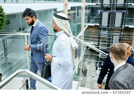 Caucasian man leads sheikh tohave conversation Caucasian man leads sheikh tohave conversation 67369397