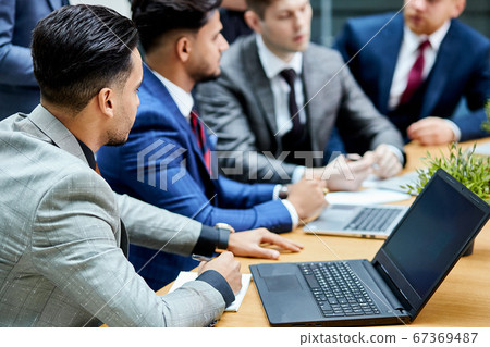 Business people use laptop while having conversation 67369487