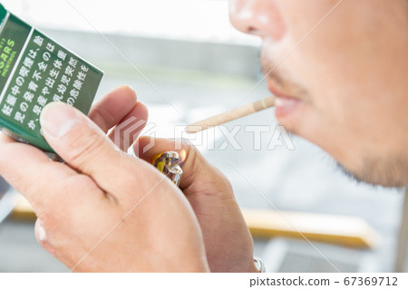 一支香煙的男人的手 67369712