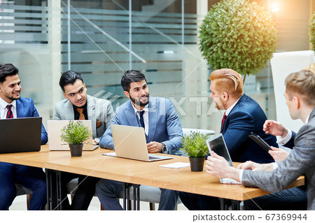 Young negotiators speaking at multi-ethnic office meeting Young negotiators speaking at multi-ethnic office meeting 67369944