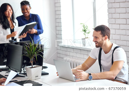 Smiling caucasian man work on laptop sitting in office 67370059