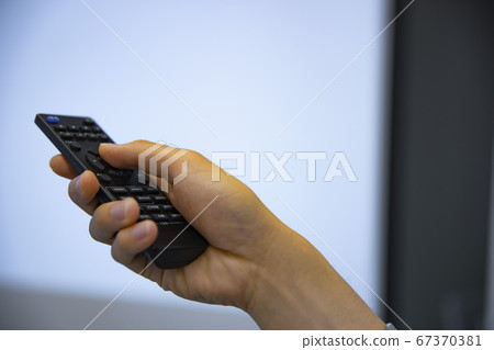 Hand holding remote control Hand holding remote control 67370381