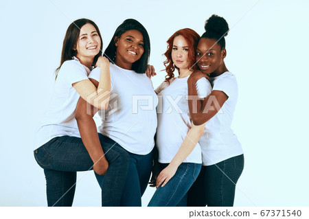 Two multicultural couples of women in casuals looking happy together on white 67371540
