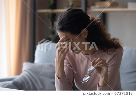 Unwell young woman take off glasses suffering from migraine Unwell young woman take off glasses suffering from migraine 67371812