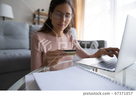 Young Caucasian woman shopping online using credit card 67371857