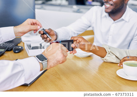close-up photo of salesman's hand giving business card and keys to buyers close-up photo of salesman's hand giving business card and keys to buyers 67373311
