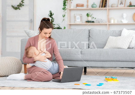 Mom With Laptop Surf On Internet While Newborn Sleeps On Her Lap Baby In  Reusable Cloth Baby Diapers In Cozy Room Sustainable Lifestyle High-Res  Stock Photo - Getty Images