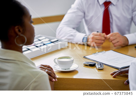 friendly manager treats customers with delicious coffee in dealership 67373845