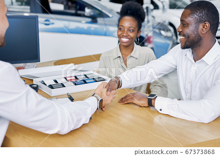 car dealer and client are shaking hands car dealer and client are shaking hands 67373868