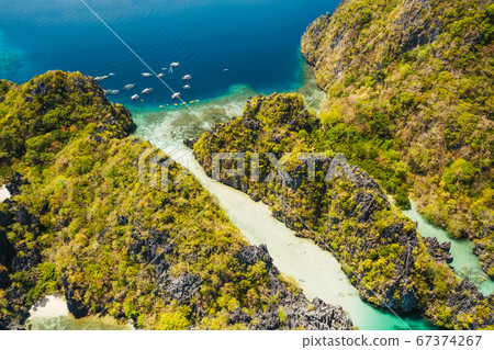 Palawan, Philippines aerial view of tropical Miniloc island. Tourism trip boats moored at entrance to big lagoon Palawan, Philippines aerial view of tropical Miniloc island. Tourism trip boats moored at entrance to big lagoon 67374267