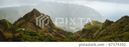 Panoramic view of mountain tops of Ribeira de Janela on Santo Antao Cape Verde. Beautiful unforgeable landscape with hiking trail leading to ocean coast Panoramic view of mountain tops of Ribeira de Janela on Santo Antao Cape Verde. Beautiful unforgeable landscape with hiking trail leading to ocean coast 67374392