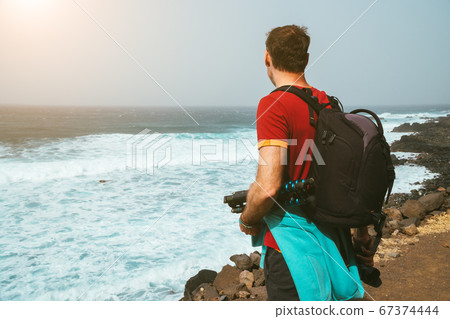 Men photograph with backpack on the scenic coast of Atlantic ocean. Hike from Cruzinha and Ponta do Sol. Santo Antao. Cape Verde Men photograph with backpack on the scenic coast of Atlantic ocean. Hike from Cruzinha and Ponta do Sol. Santo Antao. Cape Verde 67374444