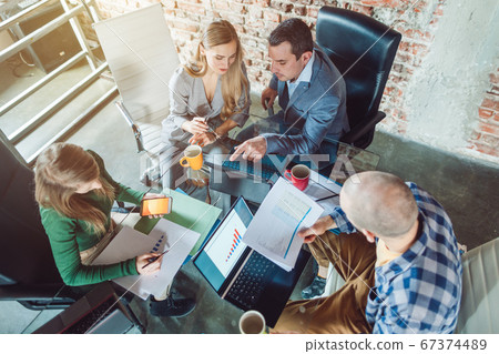 Startup team of businesspeople looking at business plan financials 67374489