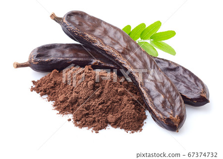 Carob beans with leaves on white background Carob beans with leaves on white background 67374732