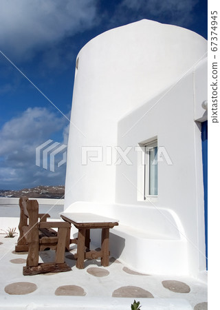 Table and bench in yard of Mykonos, Greece. House 67374945