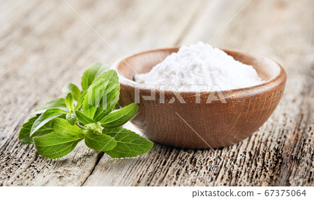 Stevia plant with powder on wooden background Stevia plant with powder on wooden background 67375064