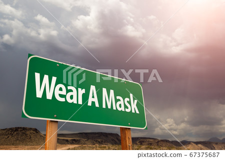 Wear A Mask Green Road Sign Against Ominous Stormy Sky 67375687