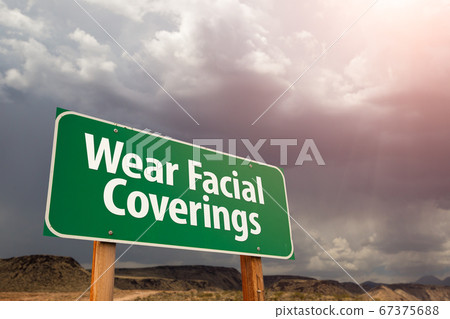 Wear Facial Coverings Green Road Sign Against Clouds 67375688