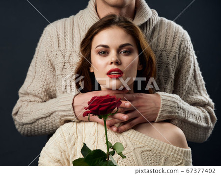 Beautiful woman with a red flower and male hands Beautiful woman with a red flower and male hands 67377402