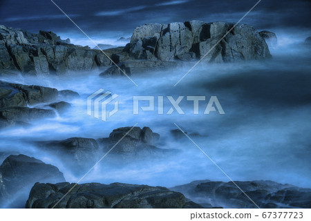 Waves rushing into the rough shore 67377723