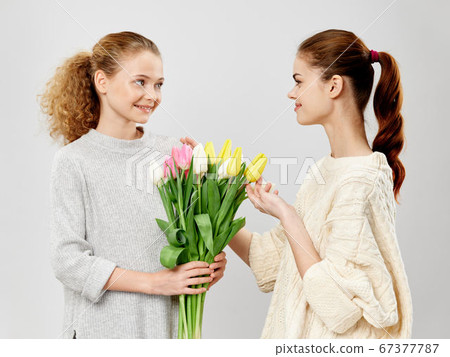 happy girl with a bouquet of tulips and a young mother happy girl with a bouquet of tulips and a young mother 67377787