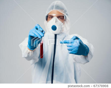 Doctor with fluid in the flask and in medical gloves mask on the face covid-19 Doctor with fluid in the flask and in medical gloves mask on the face covid-19 67378908
