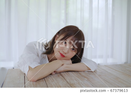 手肘在桌上的年輕女子 手肘在桌上的年輕女子 67379613