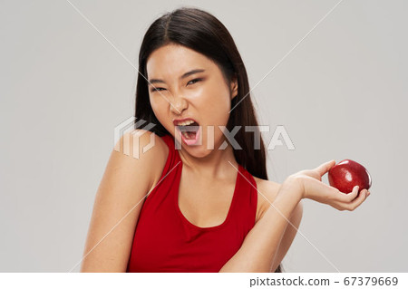 Happy woman with apple in hand wide open mouth Happy woman with apple in hand wide open mouth 67379669