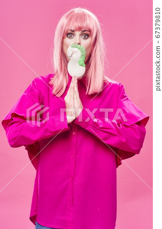 Woman in a pink shirt with a cake in her hands and hair model Woman in a pink shirt with a cake in her hands and hair model 67379810