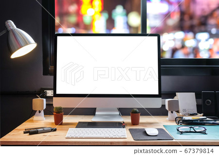 Graphic designer's workspace with city night view 67379814