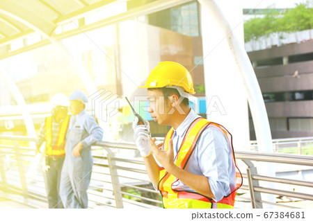 the engineer using radio in hand talk to the team 67384681