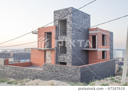 Facade of an unfinished two-story house with no red brick windows