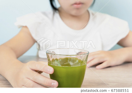 Girl drinking vegetable juice. Kids drinking smoothies 67388551