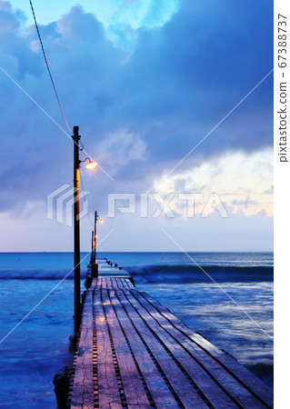 A beach with a pier that can be reached at dusk A beach with a pier that can be reached at dusk 67388737