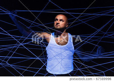 Man tangled in white threads with hands up Man tangled in white threads with hands up 67389996