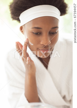 Woman applying moisturizer to her face Woman applying moisturizer to her face 67394457