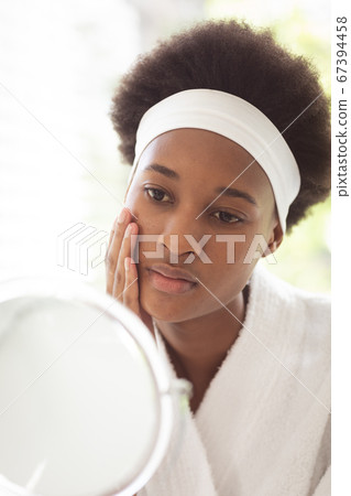 Woman looking in the mirror Woman looking in the mirror 67394458