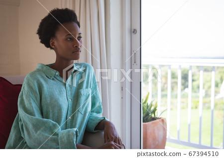 Woman looking out of the window Woman looking out of the window 67394510