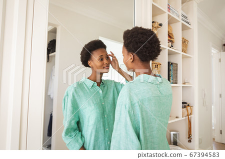Woman looking in the mirror Woman looking in the mirror 67394583