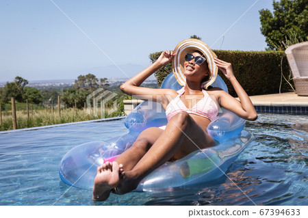Woman floating on inflatable ring in the pool Woman floating on inflatable ring in the pool 67394633