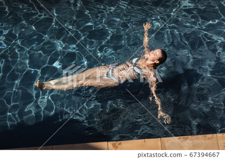 Woman swimming in the pool 67394667