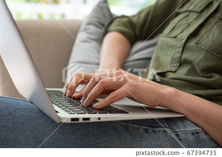 Mid section of woman using laptop Mid section of woman using laptop 67394735