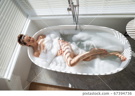 Woman relaxing in a bathtub Woman relaxing in a bathtub 67394736