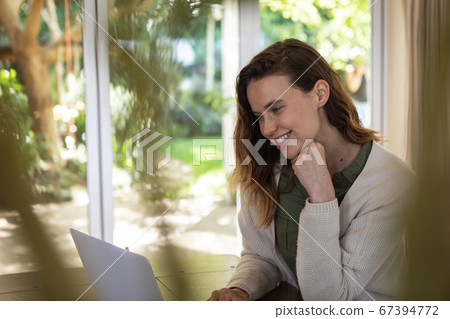 Woman using laptop at home 67394772