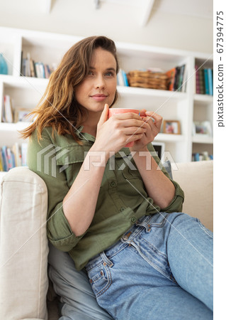Woman holding coffee cup at home Woman holding coffee cup at home 67394775
