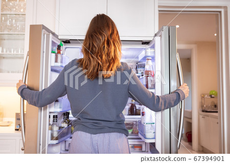 Rear view of woman opening the fridge at home Rear view of woman opening the fridge at home 67394901